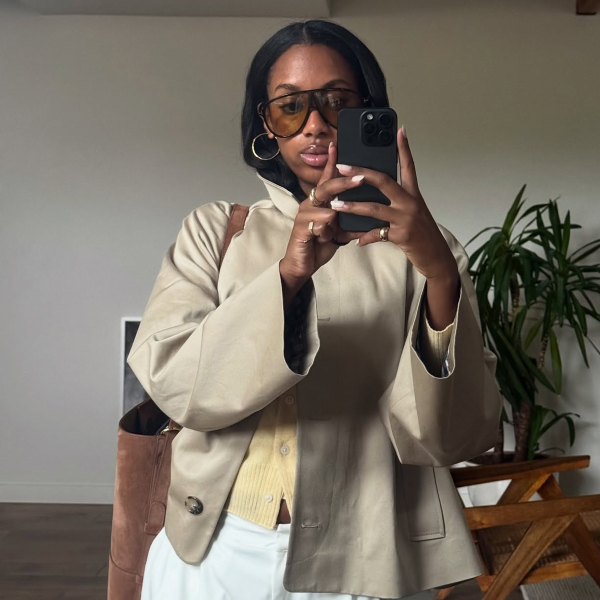 @claire_most wearing white linen trousers, a butter yellow cardigan, cropped trench coat from Sezane