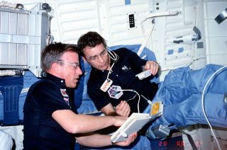 STS-6 mission specialist Don Peterson with commander Paul Weitz on space shuttle Challenger in 1983.