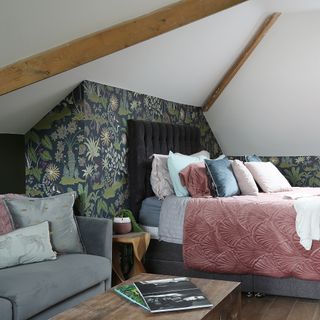 Attic bedroom with floral wallpaper, white ceiling and wooden beams