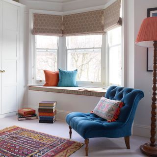 white wall room with window side seating blue chair cushion