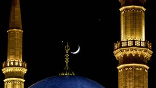 A crescent moon is seen in a rare alignment with the planets Jupiter (R) and Venus (L) over Beirut's landmark Mohammed al-Amin mosque on December 1, 2008.