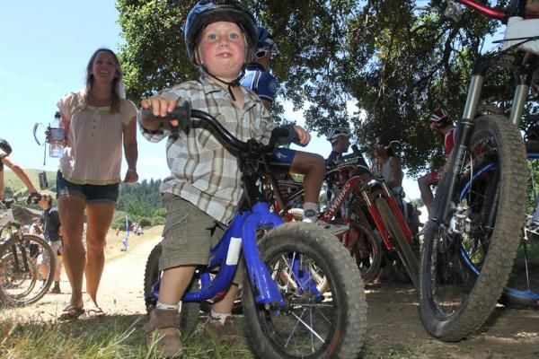 Perhaps a future champion, two-year-old Vaughn Kirberg rides his push-bike through the crowds following the race.