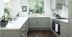 Green kitchen with white countertops to support key kitchen cleaning mistakes