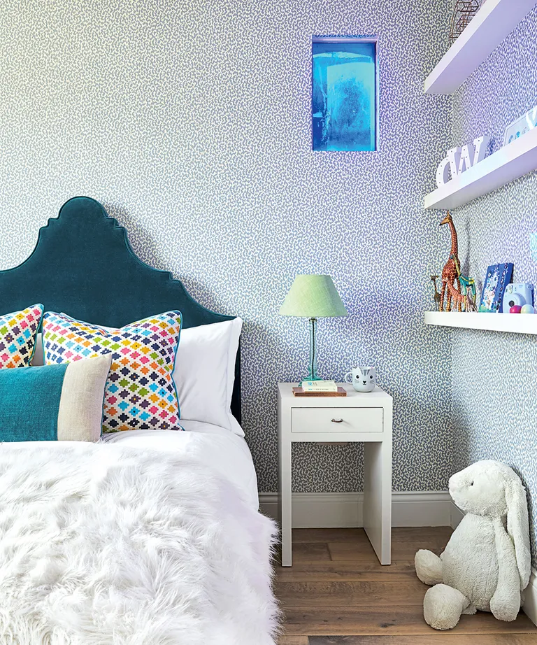 Kid's bedroom with blue headboard and shelving