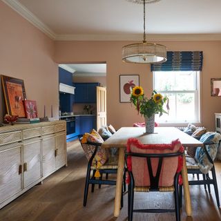 wooden dining table with chairs with colourful cushions