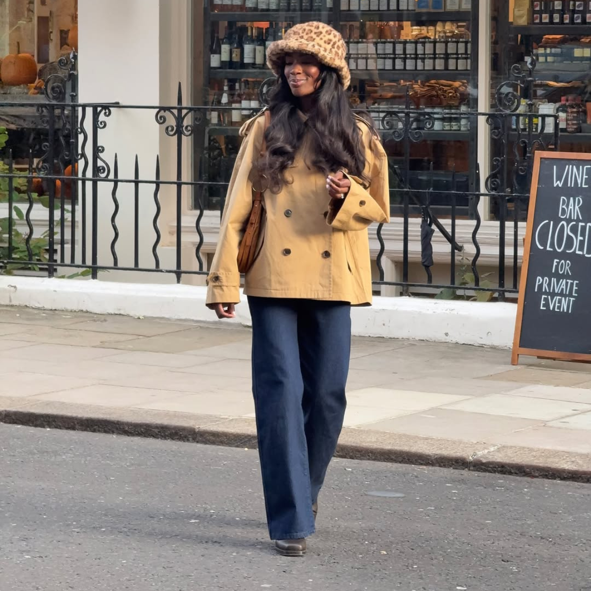 Influencer Liv Madeline wearing a cropped trench coat and flared jeans.