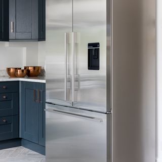 Souble silver fridge freezer in kitchen with blue cabinetry