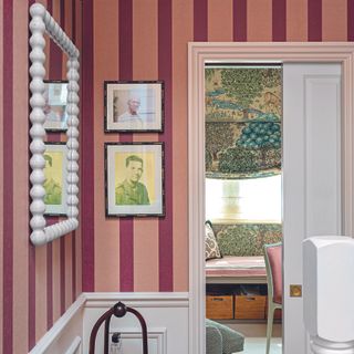 Hallway with red and pink striped wallpaper.