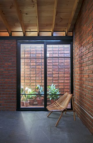 interior looking to courtyard of brick house by Natura Futura