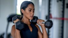 Woman doing shoulder presses with a pair of dumbbells