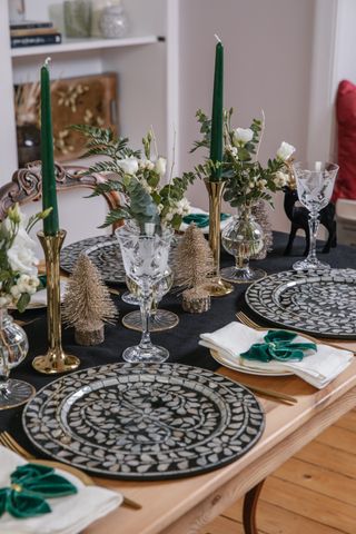A dining table laid for Christmas dinner with blue and white themed decor