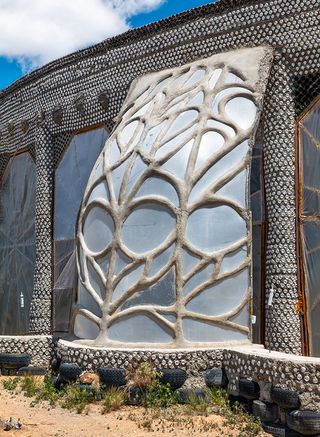 Earthship community in Taos showing colourful off grid homes nestled into the desert earth