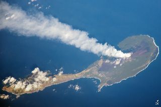 A steam plume drifts away from a volcano on Pagan Island, part of the Commonwealth of the Northern Marianas.