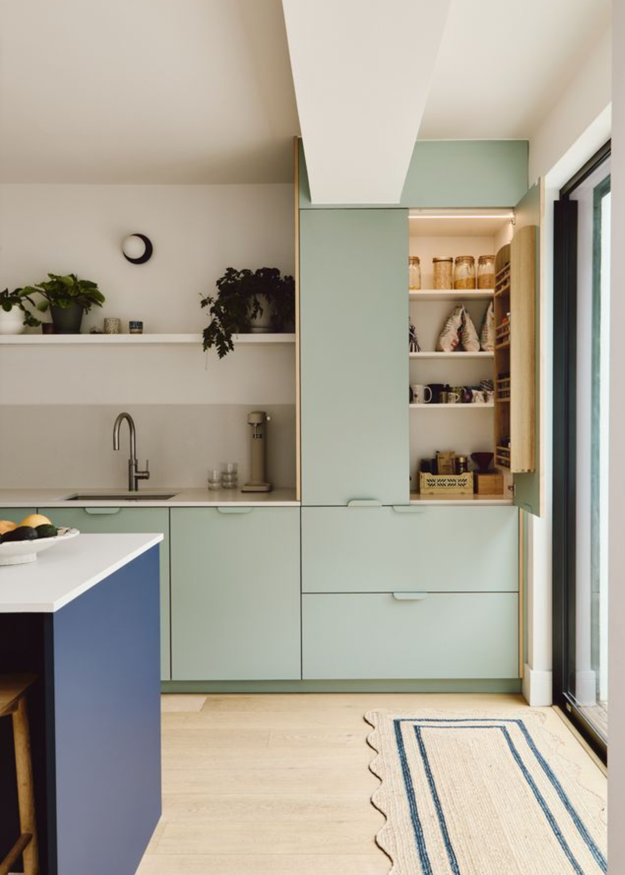 a modern kitchen with green cabinets with contrasting shades of green as accents