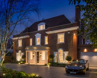 large house and driveway with lights