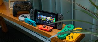 A Nintendo Switch surrounded by multiple types of controller