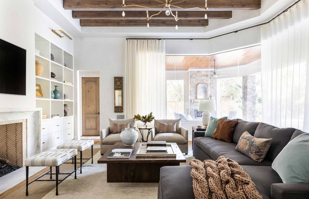 a living room with cream curtains