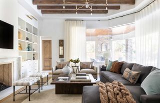 a living room with cream curtains