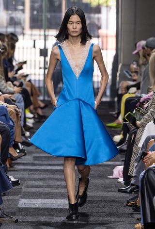 a model on the JW Anderson spring 2025 runway wearing a blue structural drop waist dress