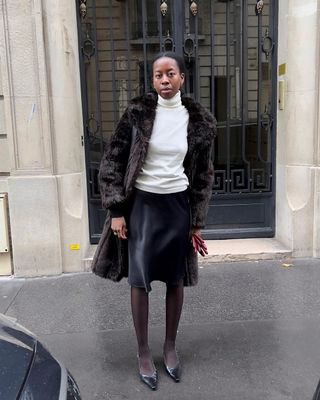 @sylviemus_ wearing a slip skirt with jumper and faux fur coat