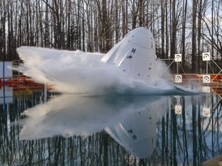 A mockup of SpaceX's Crew Dragon capsule with two crash test dummies inside splashes into the water during a drop test at NASA's Langley Research Center in Hampton, Virginia. SpaceX conducted a series of these drop tests in March 2019 to find out how different wind and parachute dynamics affect the capsule during a splashdown, and to make sure its astronaut occupants can safely return to Earth.