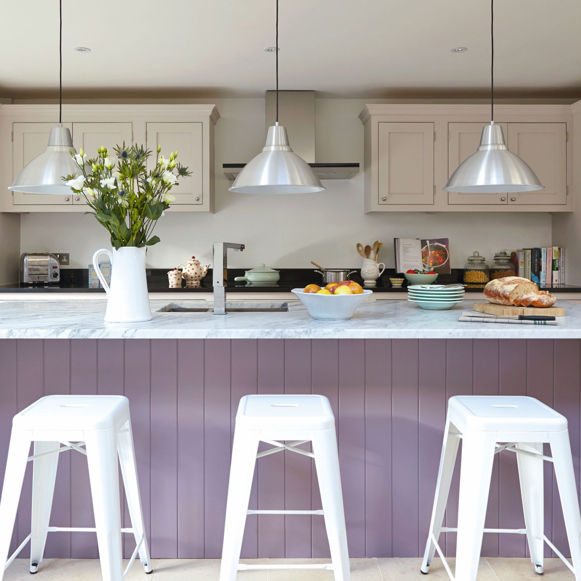 Modern hwite kitchen, large lilac breakfast bar with high bar stools, low hanging pendant lights
