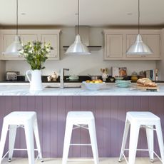 Modern hwite kitchen, large lilac breakfast bar with high bar stools, low hanging pendant lights