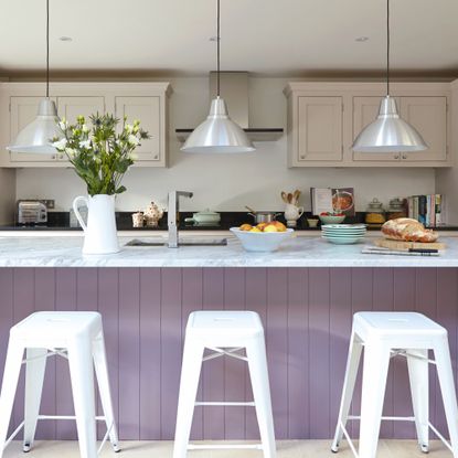 Modern hwite kitchen, large lilac breakfast bar with high bar stools, low hanging pendant lights