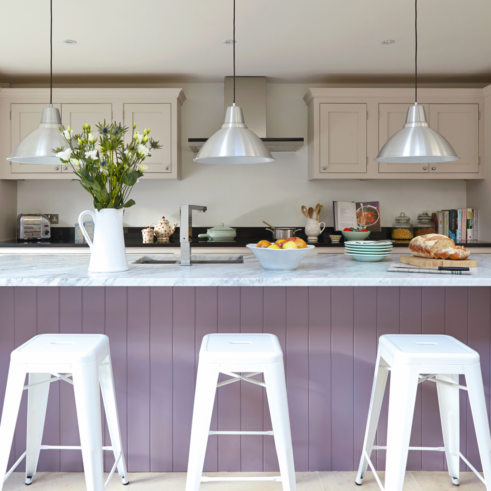 Modern hwite kitchen, large lilac breakfast bar with high bar stools, low hanging pendant lights