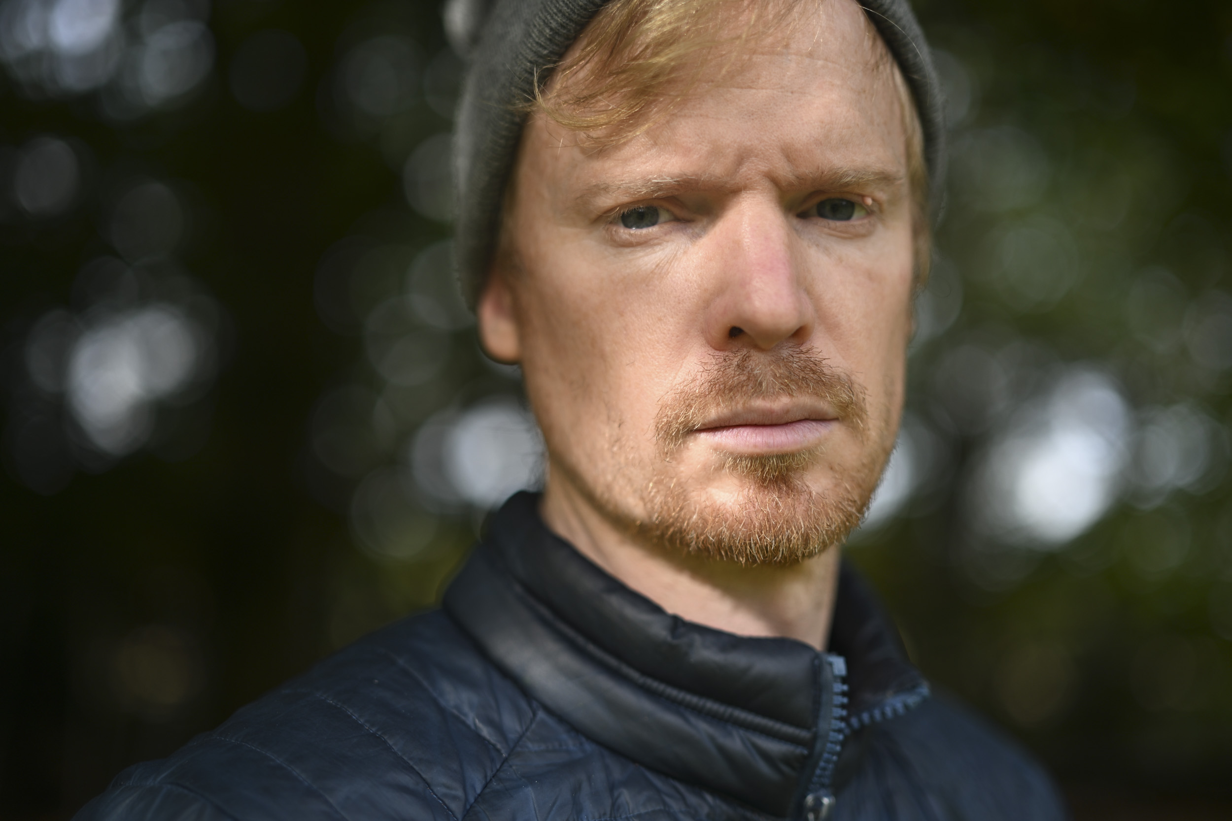 Head and shoulder portrait, outdoors, shallow depth of field, dappled light through tree leaves