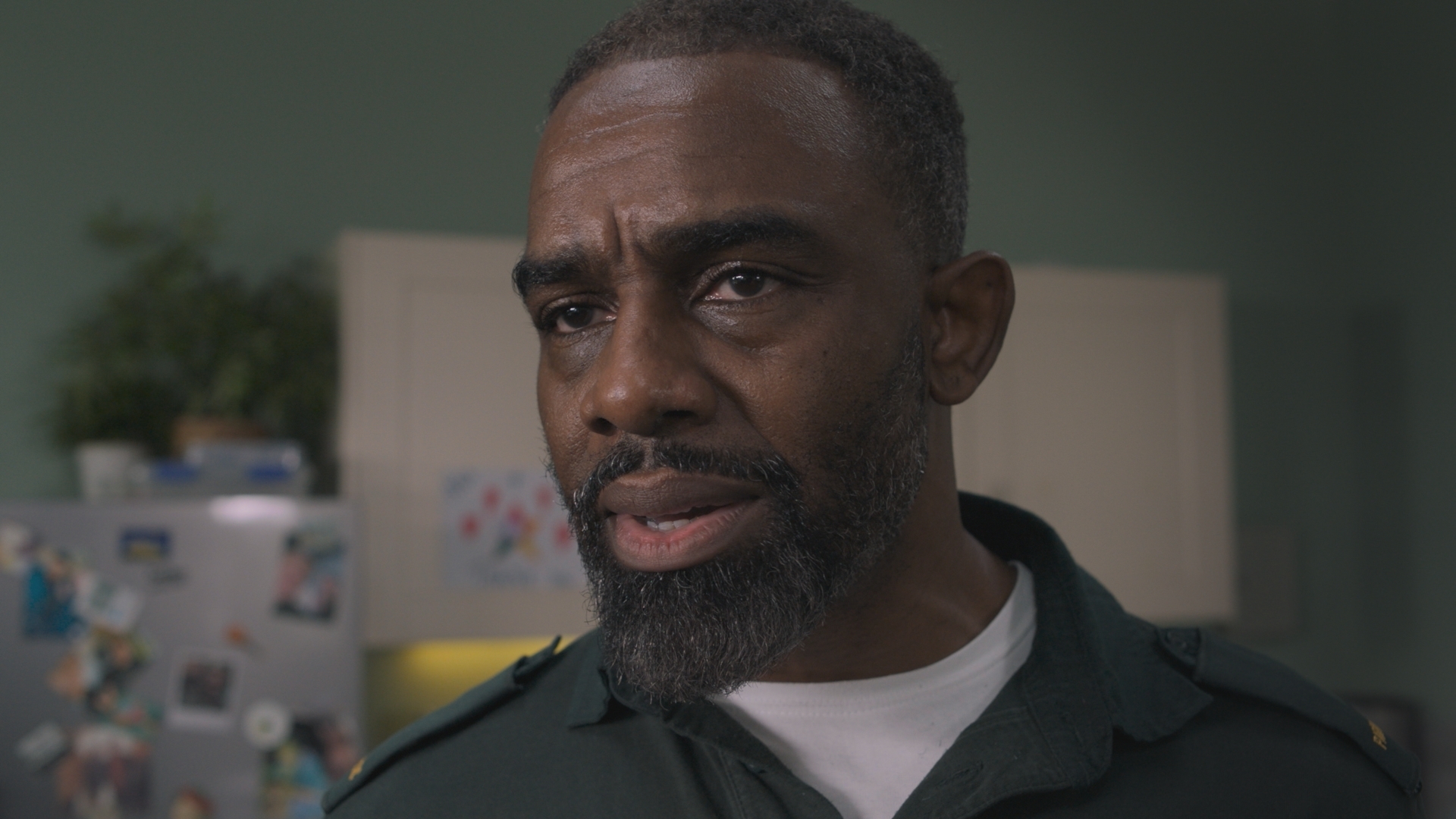 Paramedic Jacob Masters in uniform, looking stressed as he stands in the ambulance station's staff room.