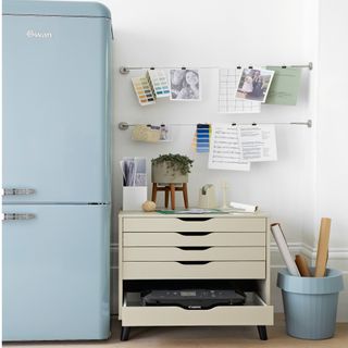 blue fridge freezer, blue bin and grey chest of drawers