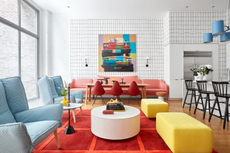colorful townhouse with white walls, and furniture and rugs in primary colors of blue, red and yellow