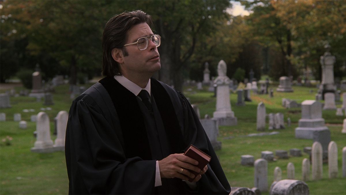 Stephen King as a priest in Pet Sematary in a graveyard