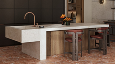 kitchen island that is half marble half wood in the centre of the room. The floor is a red marble.