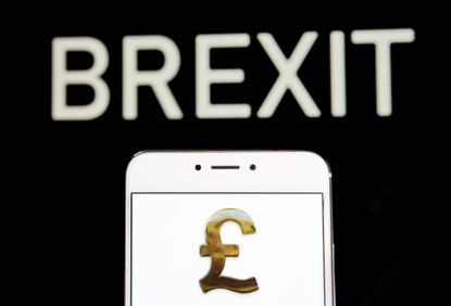HONG KONG - 2019/04/20: In this photo illustration a Great Britain's currency Pound Sterling icon is seen on an Android mobile device with a Brexit message in the background. (Photo Illustrat