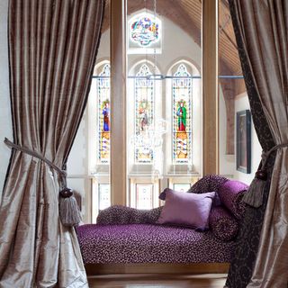 purple chaise lounge with curtain and window