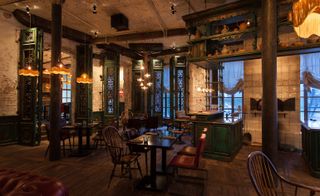 Kazbek restaurant in Moscow with wood and metal shutters, wooden floor and brown and green furniture
