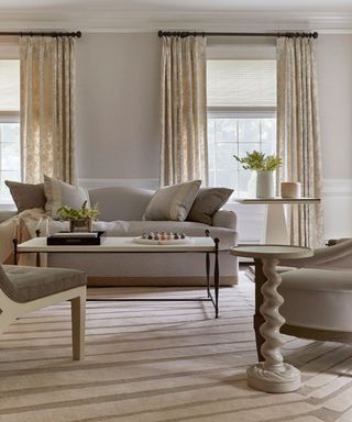 neutral living room with cream carpet, gray sofa, beige curtains and neutral walls