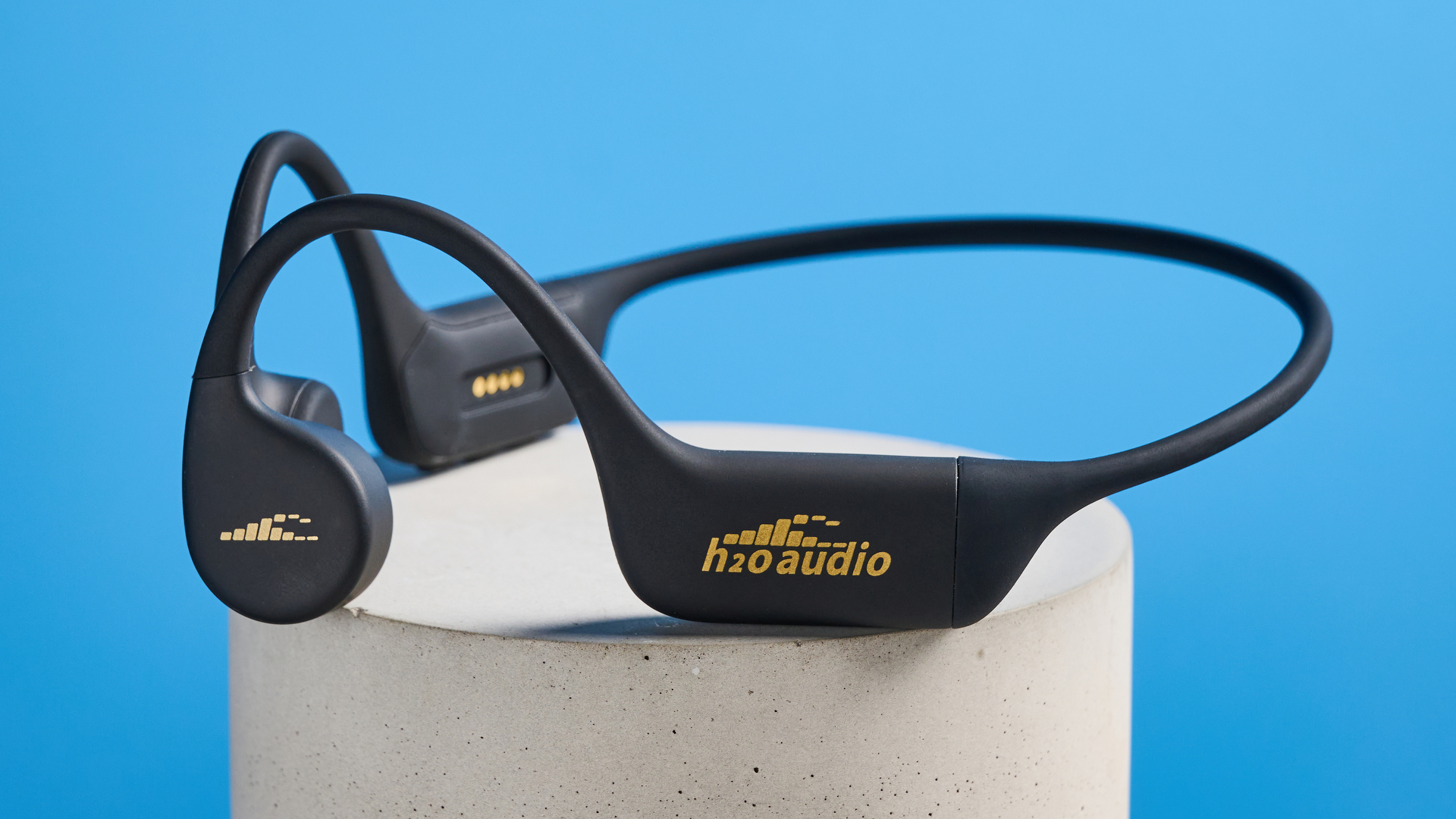 H2O Audio TRI 2 PRO headphones photographed in front of a blue background