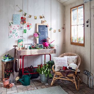 white shed with flower plants and chair