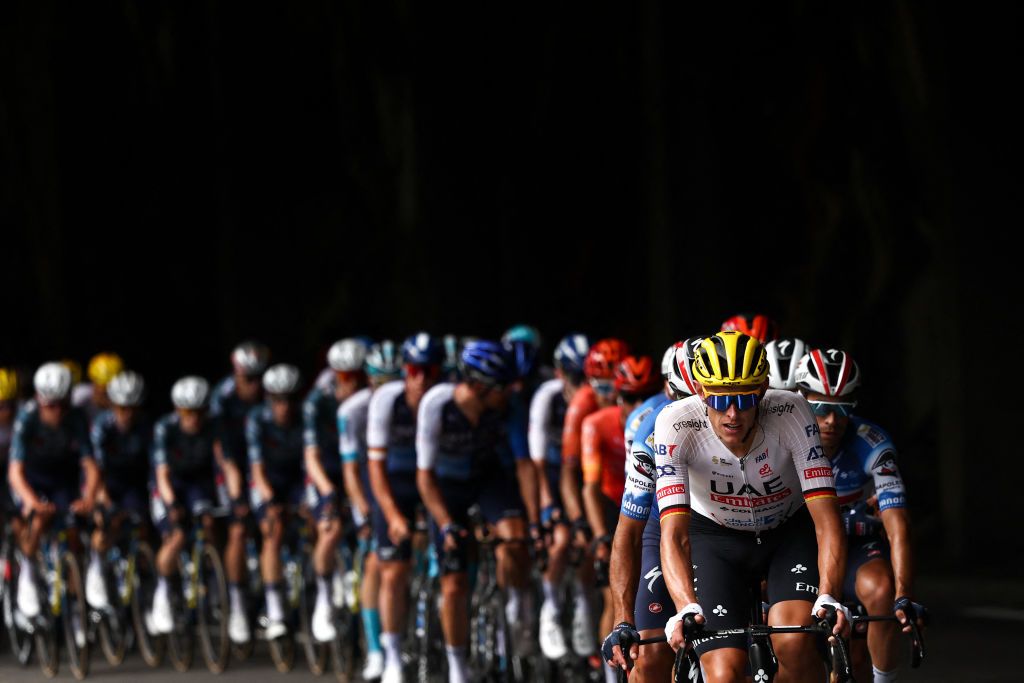 UAE Team Emirates team's German rider Nils Politt (L) leads the pack of riders (peloton) through a mountain tunnel as they cycle in the ascent of Col du Tourmalet during the 14th stage of the 111th edition of the Tour de France cycling race, 151,9 km between Pau and Saint-Lary-Soulan Pla d'Adet, in the Pyrenees mountains in southwestern France, on July 13, 2024. (Photo by Anne-Christine POUJOULAT / AFP)