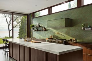 An olive green kichen with a tiled range hood