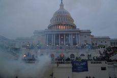 Capitol building with smoke surrounding it and rioters on it