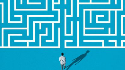 A man walks up to a complicated maze.