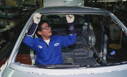 An employee in Ford's mexico-based factory works on a car.