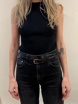Black top with black jeans and a double-wrap black and gold belt