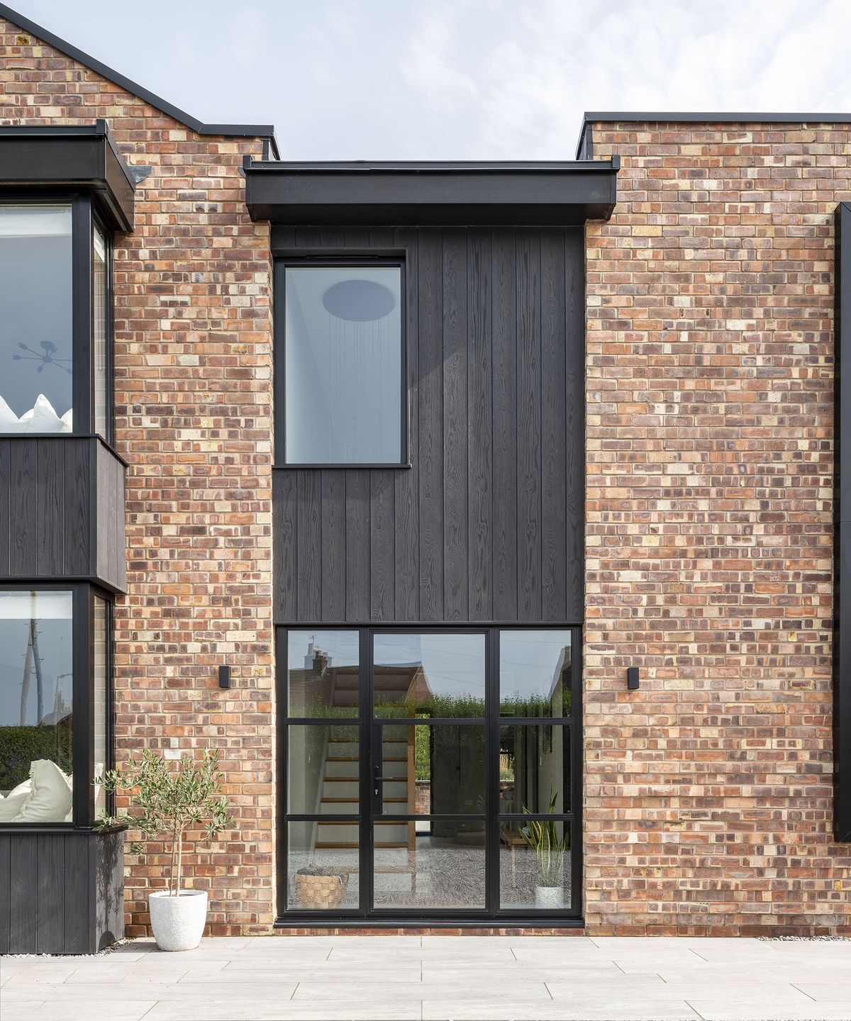 Red brick and dark timber clad exterior of a contemporary home renovation