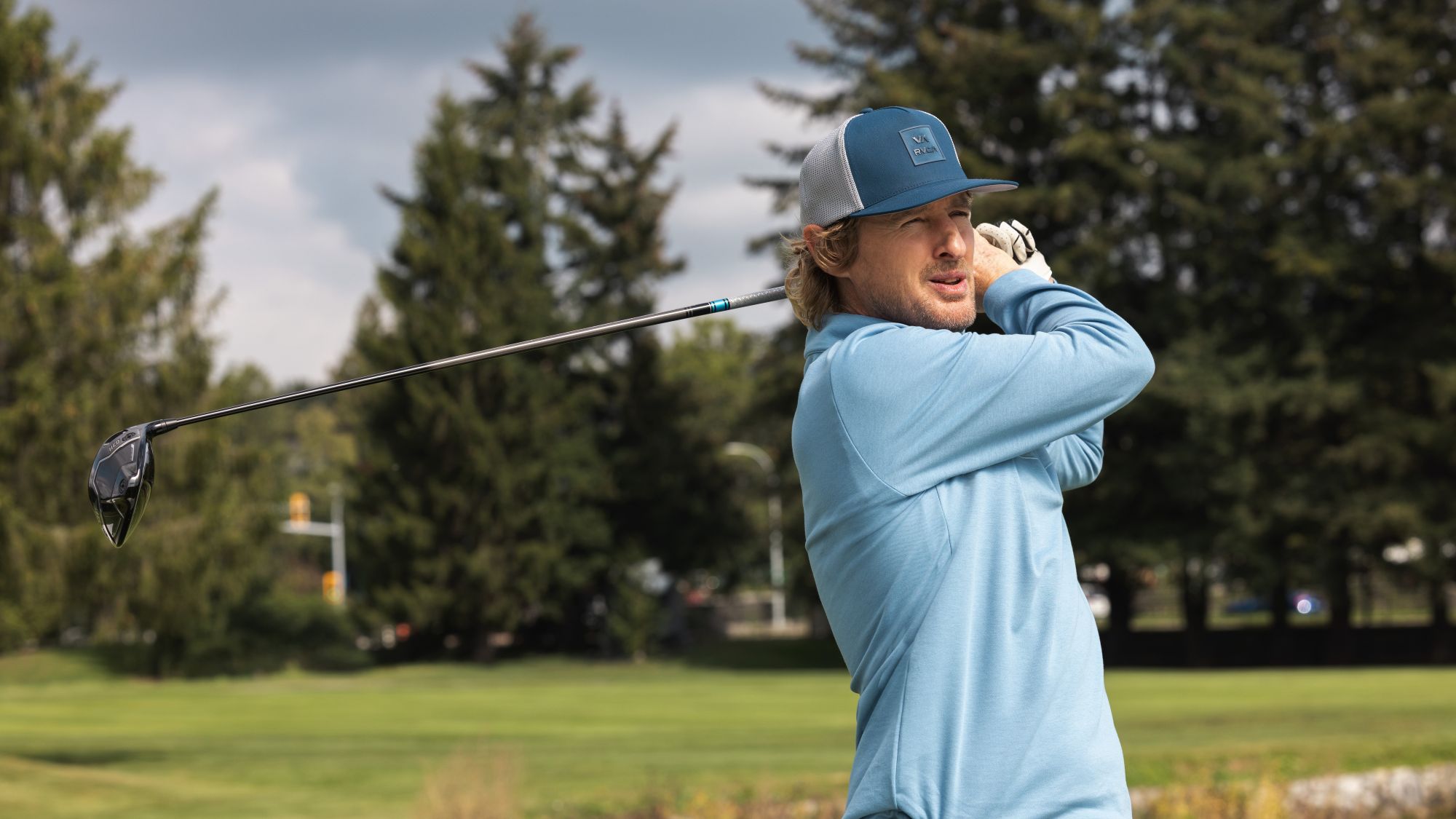 Owen Wilson swings a golf club in Stick