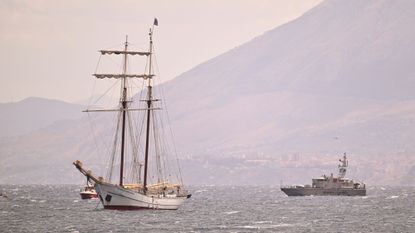 A coast guard vessel and a private sail boat assist the search for missing passengers after the yacht Bayesian capsized in a tornado